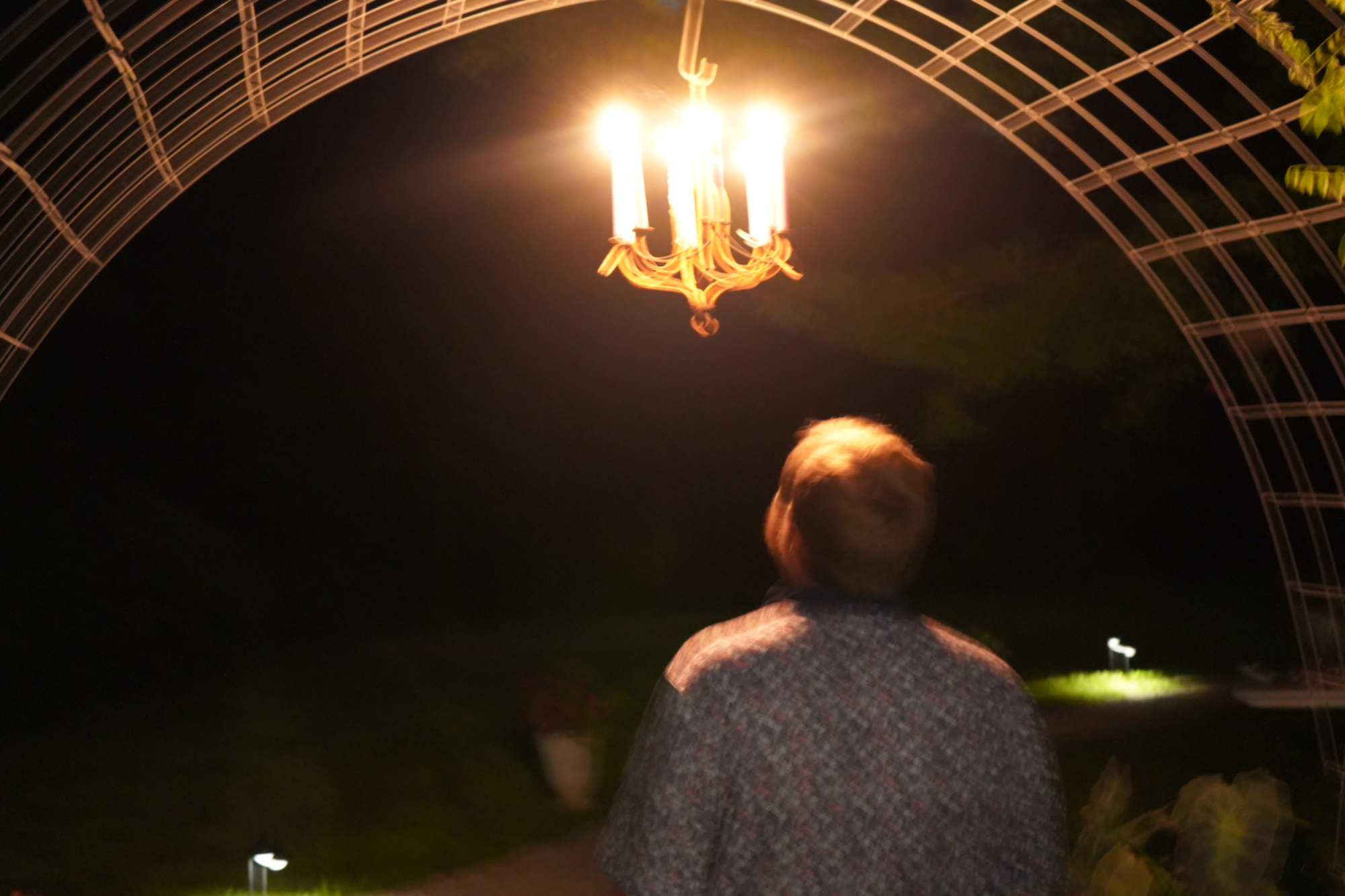 Person under chandelier at night
